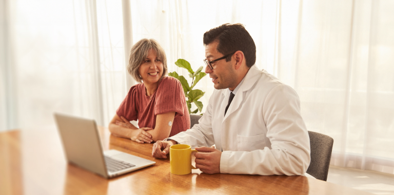 Woman wearing a FreeStyle Libre systems sensor speaking to her doctor