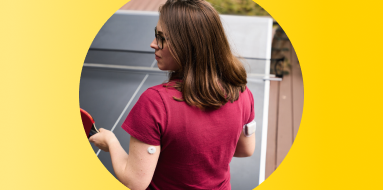 Woman playing table tennis while wearing a FreeStyle Libre 3 Plus sensor