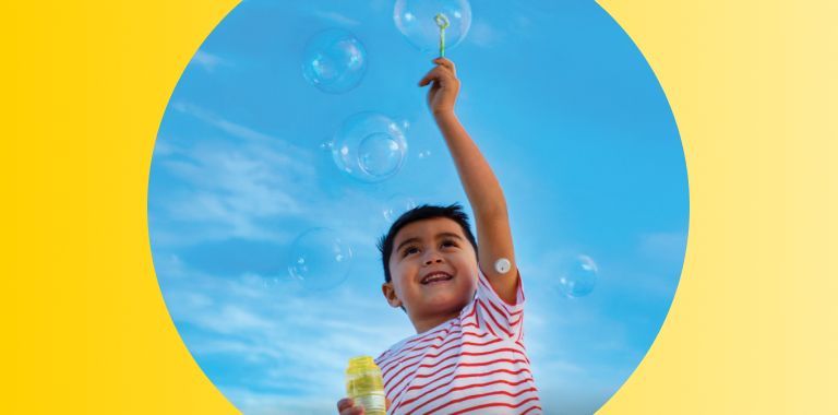 Child playing with bubbles while wearing a FreeStyle Libre 3 Plus sensor