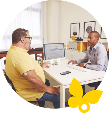 Man wearing a FreeStyle Libre 2 Plus sensor while speaking with his healthcare provider