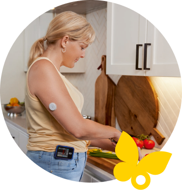Woman chopping vegetables while wearing a FreeStyle Libre 2 Plus sensor and Tandem t:slim X2 insulin pump