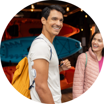 Smiling man wearing a FreeStyle Libre 2 Plus sensor and Omnipod insulin pump