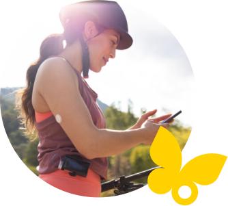 Woman checking her glucose on a smartphone while she is out for a bike ride
